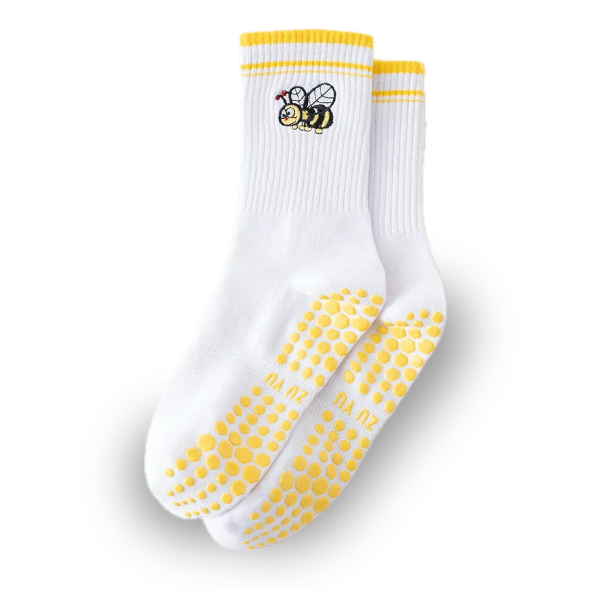 Pair of white crew grip socks with yellow cuff stripes, embroidered cartoon bumblebee near the ankle, and yellow honeycomb-style non-slip grips on the soles, displayed on a solid black background, ideal for Pilates, yoga, barre, and cute everyday wear