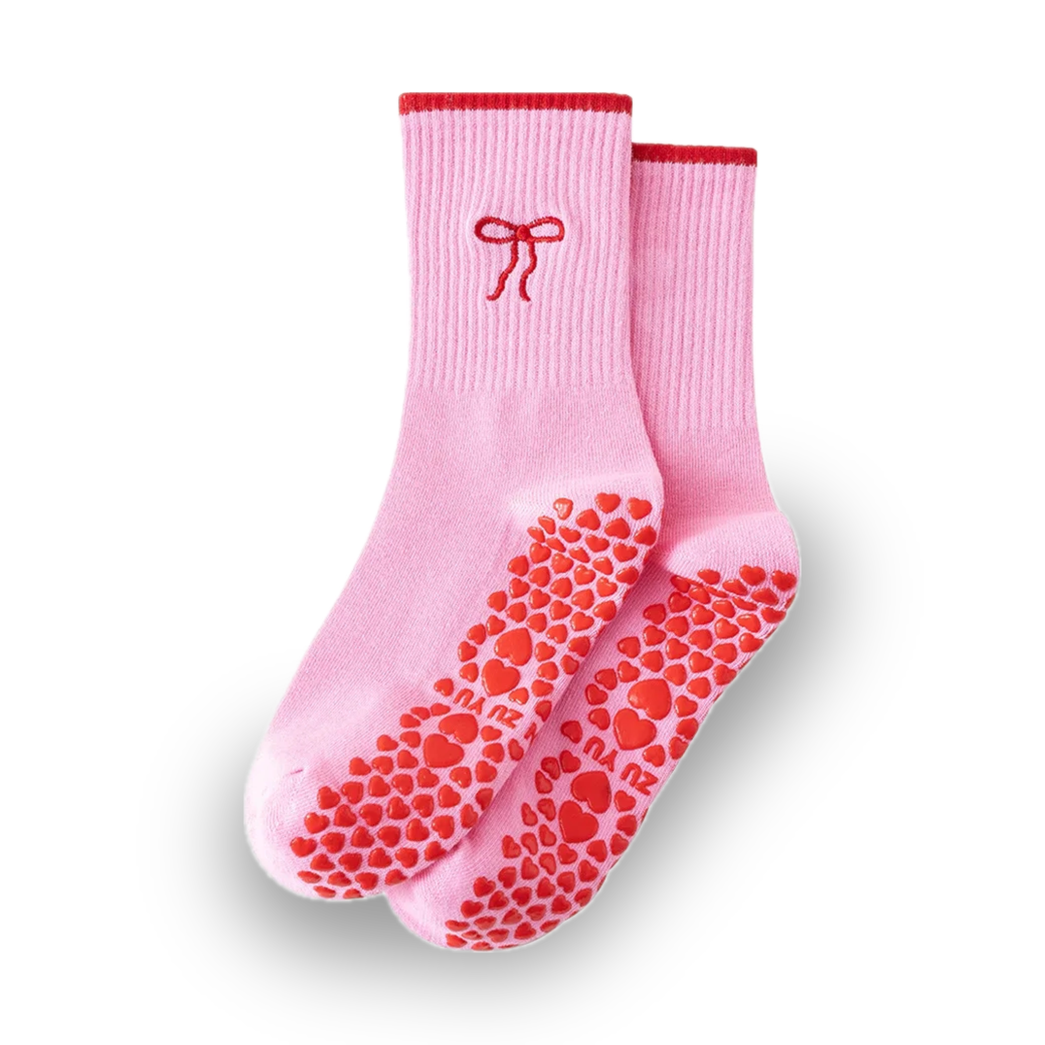 Pair of pink crew grip socks with red cuff trim, embroidered red bow near the ankle, and red heart-shaped non-slip grips on the soles, displayed on a solid black background, ideal for Pilates, yoga, barre, and balletcore fashion
